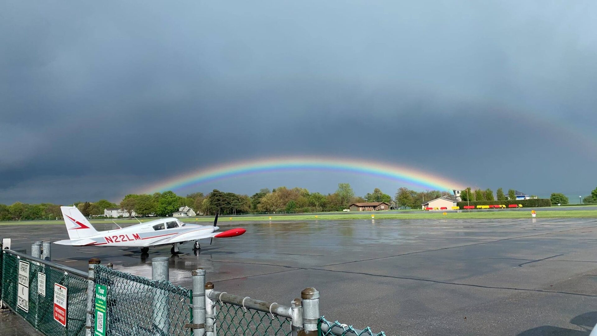 A rainbow over the water and a boat in the water.